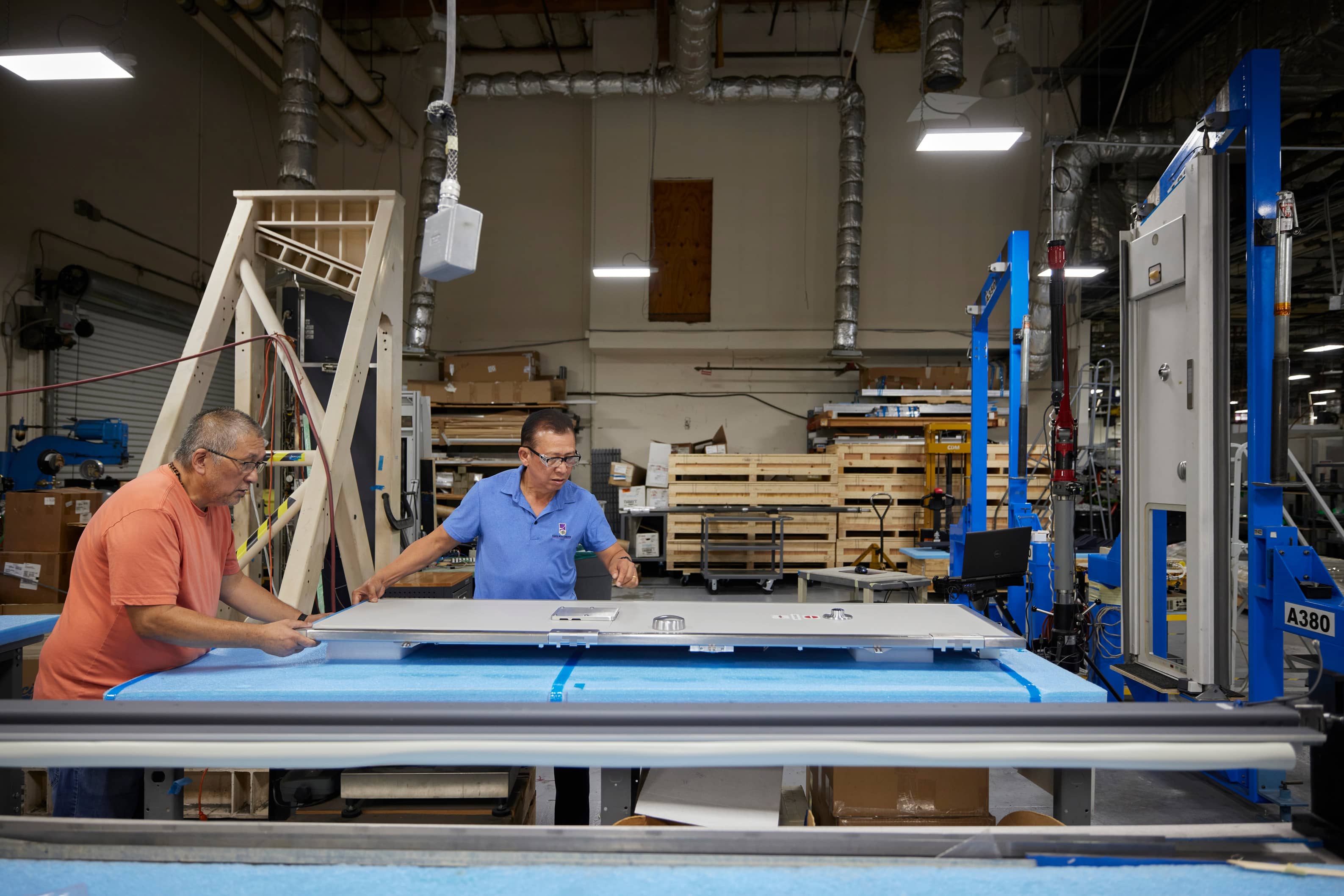 Two-employees-manufacturing-a-aircraft-cockpit-security-door