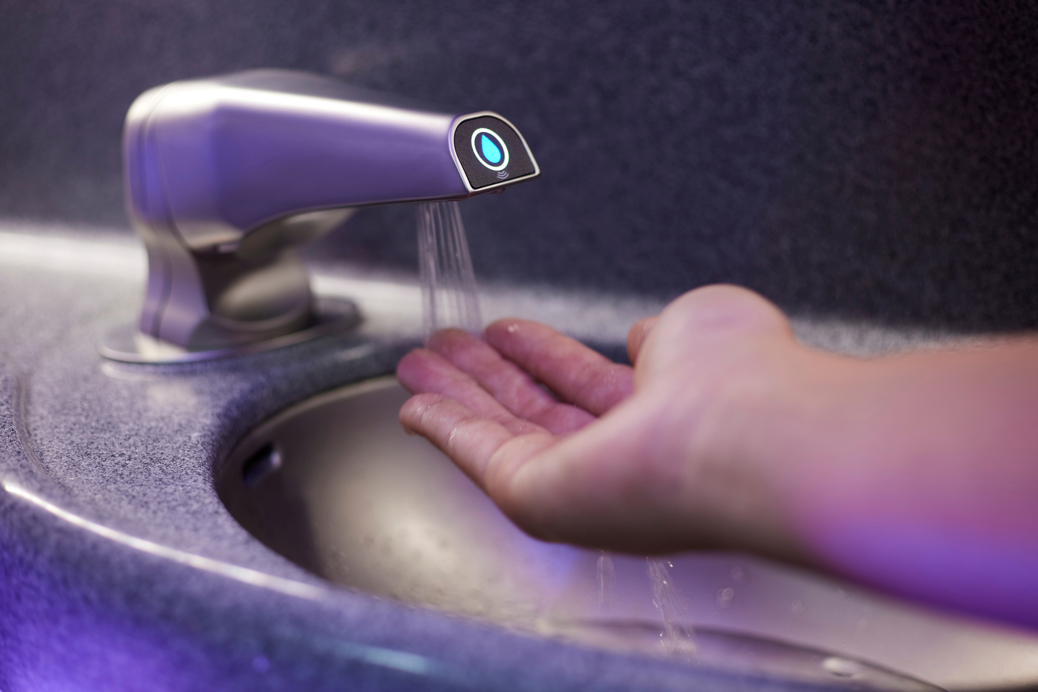 hand-beneath-touchfree-aircraft-faucet-with-water-running