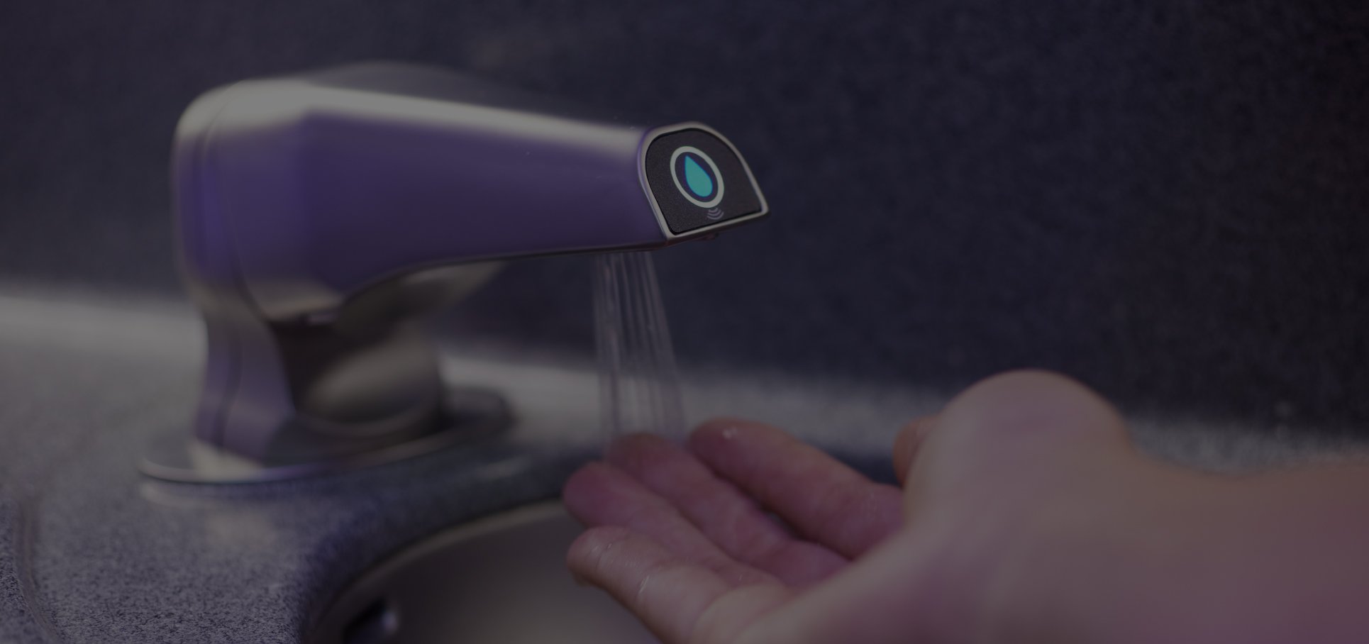Detailed-view-of-a-hand-underneath-a-touchless-aircraft-faucet-running-water